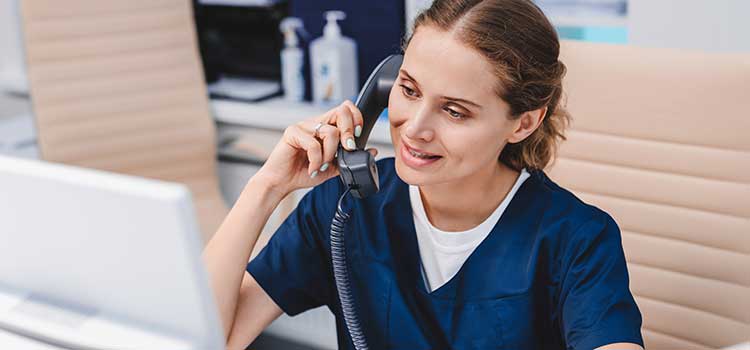 medical assistant takes appointment calls at clinic front desk