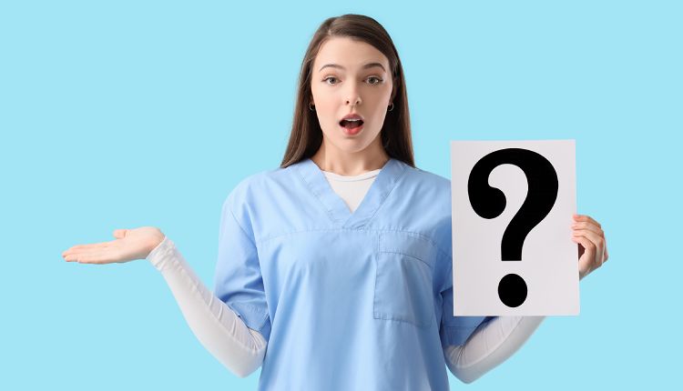 medical assistant in blue scrubs holding a question mark sign